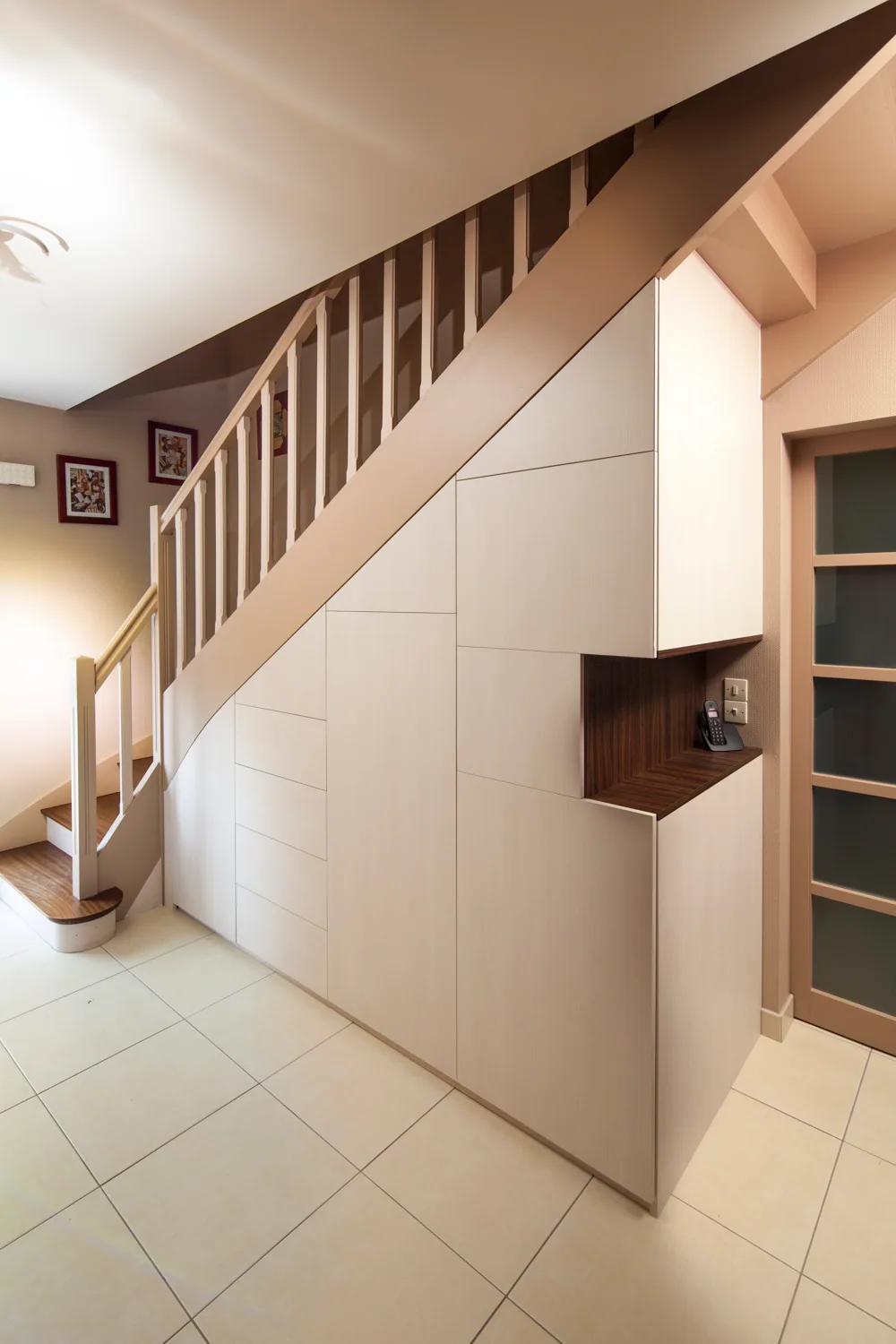 Placard sous-pente avec des portes blanches et une niche décorative réalisé par Côté Rangement